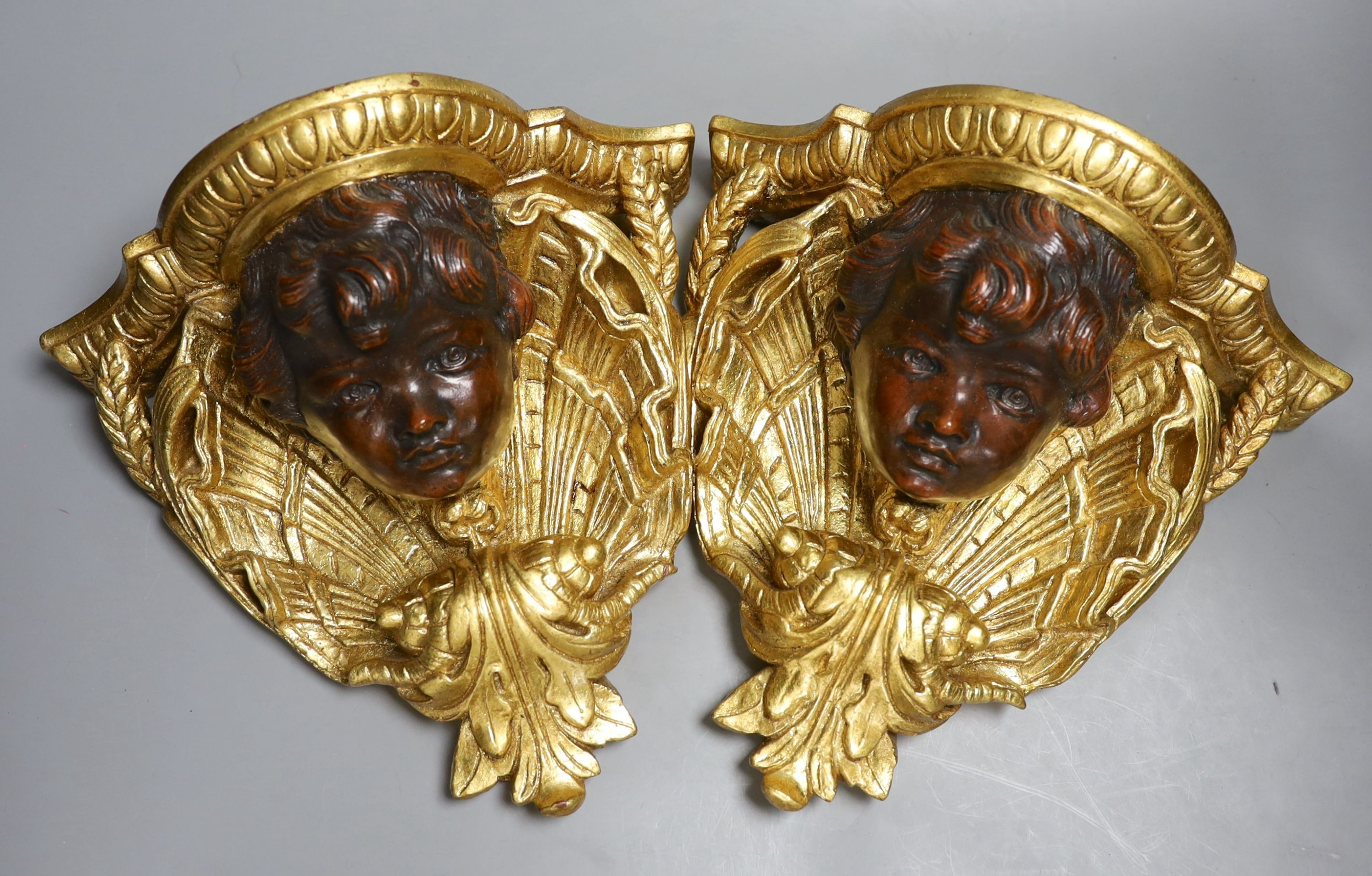 A pair of decorative gilt composition wall brackets - 26cm tall